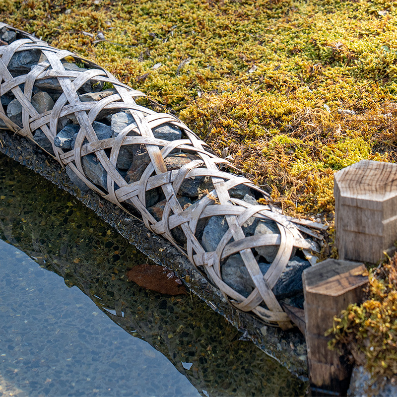 竹で編んだ筒に石を詰めている