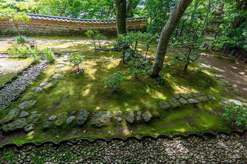 瓦を土留めにして砂利道と苔庭が仕切られている