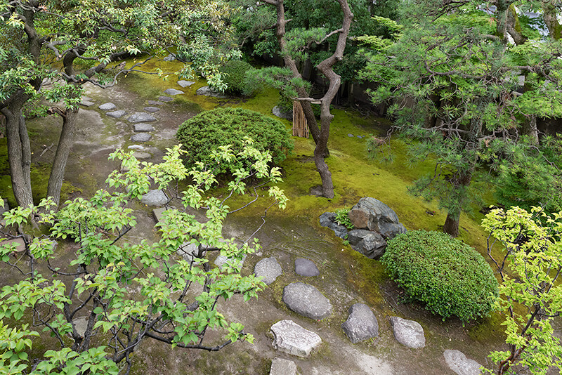 東西の伸びる邸宅に沿って飛石が打たれている
