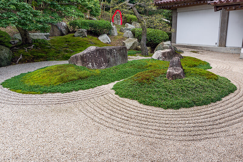 苔で覆われた築山に石が据えられている